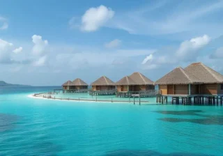 Luxury overwater villas surrounded by crystal-clear blue ocean and coral reefs in the Maldives.