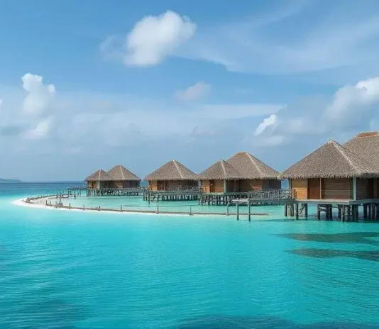 Luxury overwater villas surrounded by crystal-clear blue ocean and coral reefs in the Maldives.