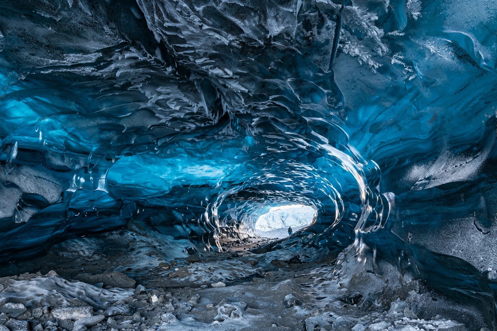Natural blue ice cave tunnel glowing sapphire inside Vatnajökull glacier, Iceland