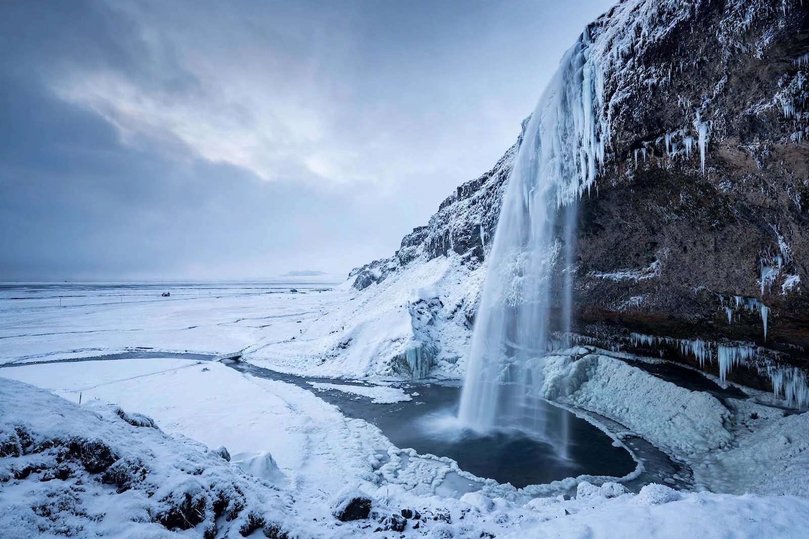 Seljalandsfoss waterfall in Iceland draped in snow and icicles during winter