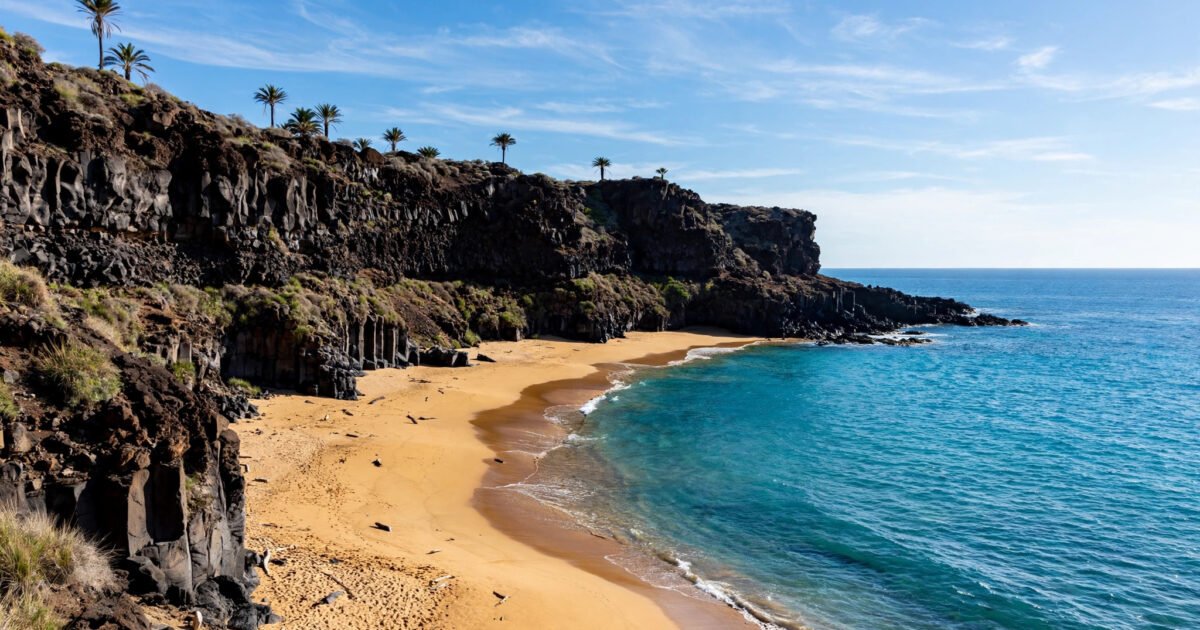 Sunny Canary Islands coastline with volcanic cliffs and golden beach in January